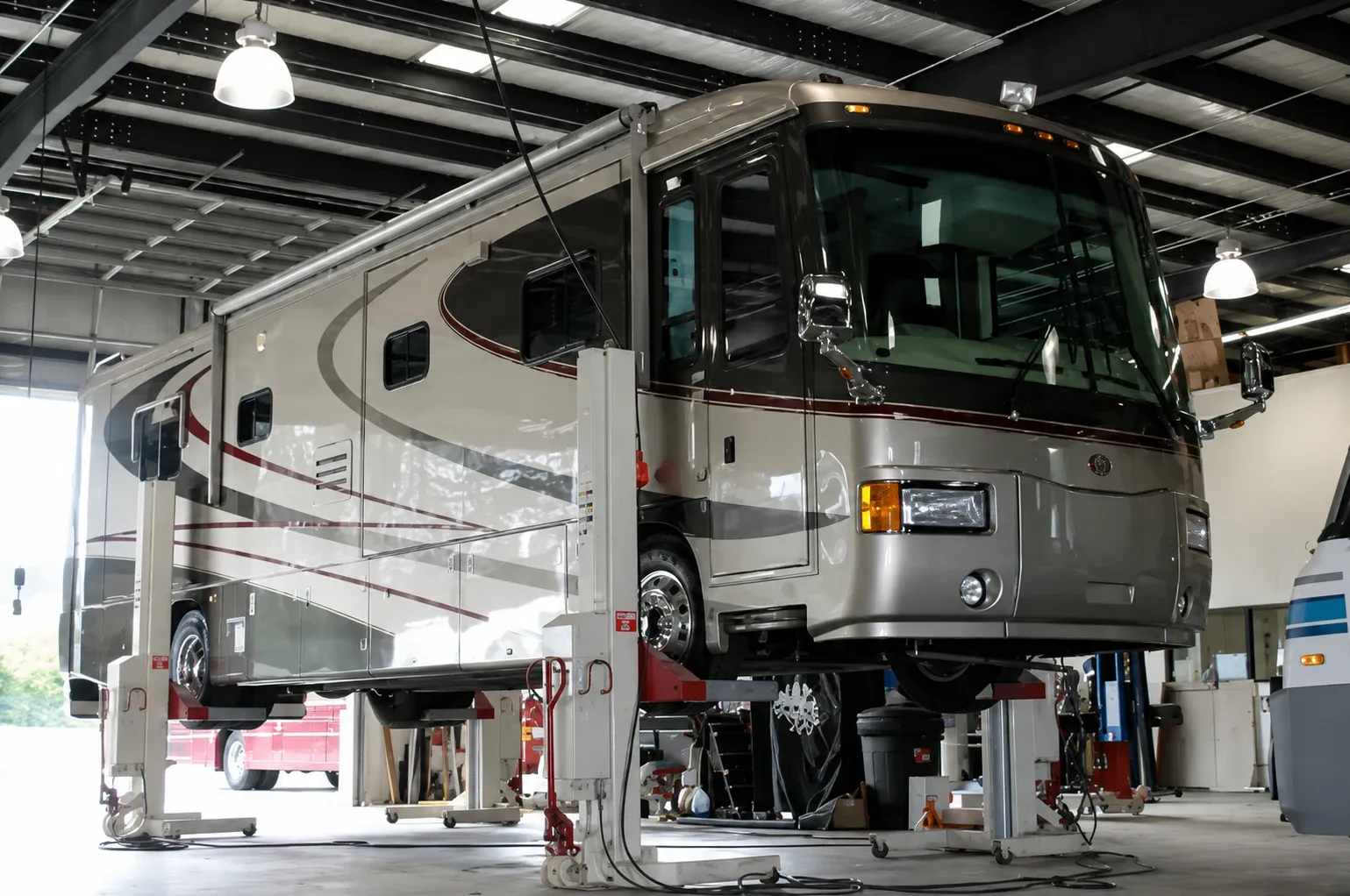 Motorhome raised on lifts in a service bay for repair